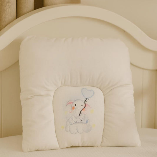Beige baby crib bumper with embroidered design of a bear holding a heart-shaped balloon.