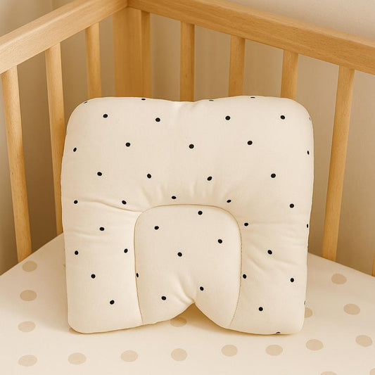 Baby crib with a polka dot cushion and matching mattress cover.