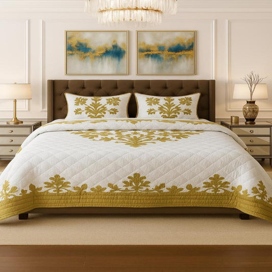 Bedroom with a bed featuring a white quilt with gold patterns, two nightstands with lamps, and abstract art on the wall.