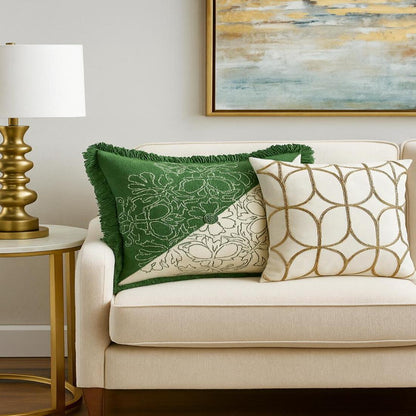 Decorative pillows on a beige sofa with a lamp and abstract painting in the background