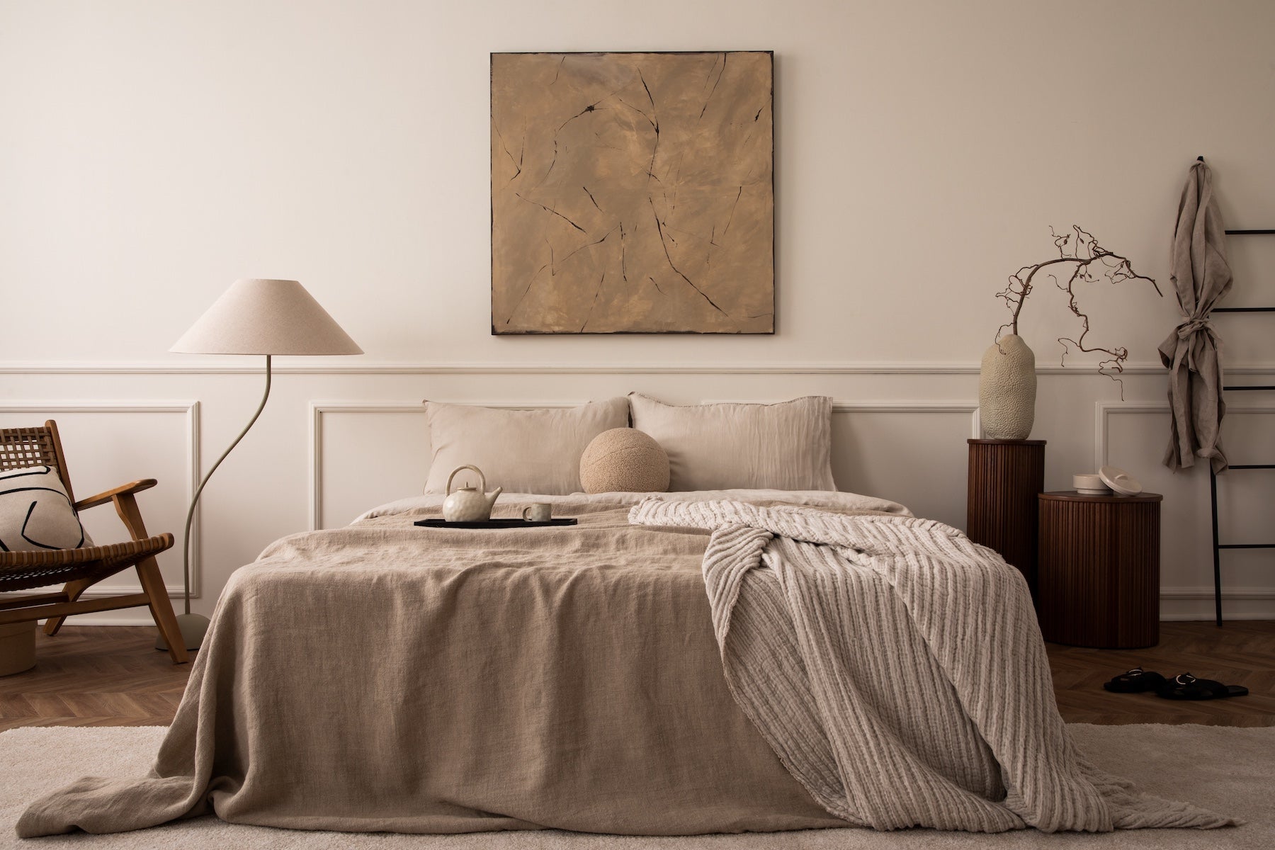 Bedroom with bed, pillows, and decor in neutral tones.