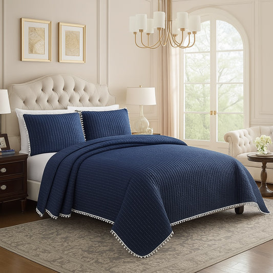 Navy blue quilt set on a bed in a stylish bedroom with large windows.